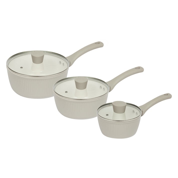 Three-piece ribbed pan set in a soft cream color, featuring glass lids and ergonomic handles for easy handling, made from durable material for versatile cooking.