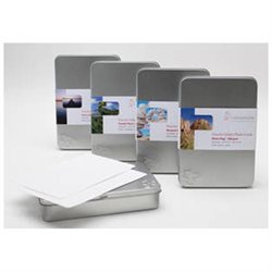Silver tin box containing Hahnemühle Photo Rag paper, featuring five packs of 10cm x 15cm sheets, showcasing a smooth, white texture ideal for high-quality prints.