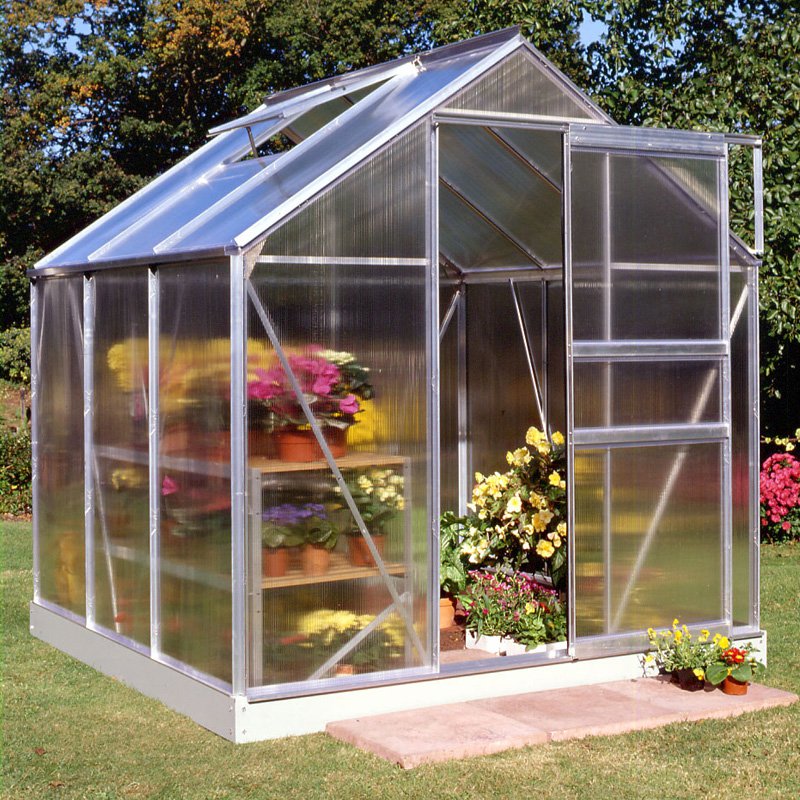 A 6'x6' aluminum frame greenhouse with polycarbonate panels, featuring a sloped roof, double door entrance, and colorful potted flowers inside, set on a grassy area.