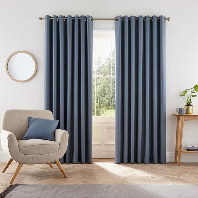 Blue lined curtains measuring 66" x 72", featuring a sleek design with metal eyelets, hanging elegantly beside a window in a modern interior setting.