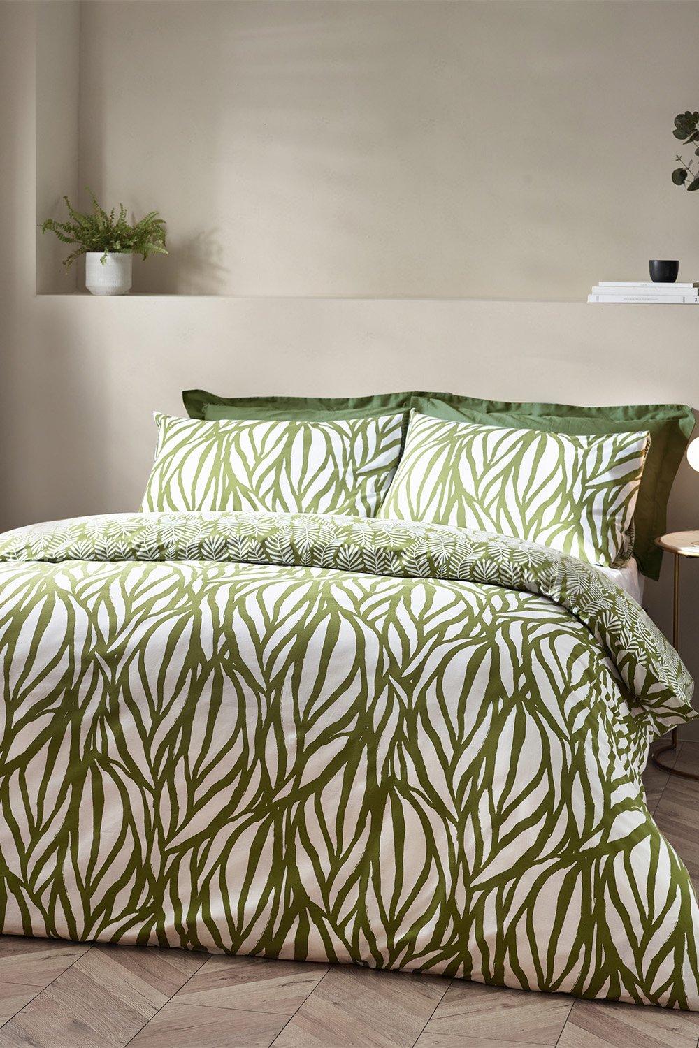 Olive green and white cotton-rich duvet cover set featuring a botanical frond pattern, includes matching pillowcases, styled on a bed with a neutral backdrop.