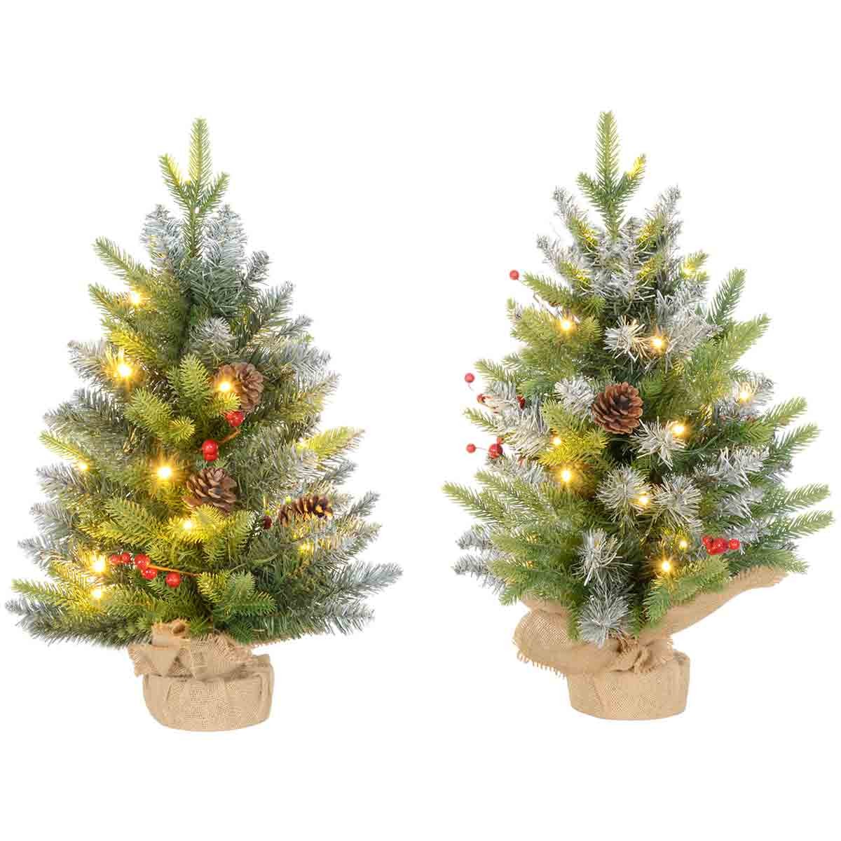 Two 2ft green tabletop Christmas trees with LED lights, featuring a concrete base, adorned with pinecones and red berries, and wrapped in burlap at the base.