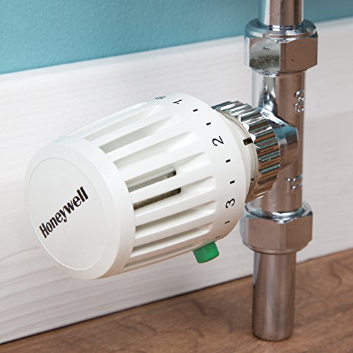 White Honeywell Home Valencia TRV with a numbered dial, attached to a shiny silver 15mm straight body valve, set against a light blue wall and wooden surface.
