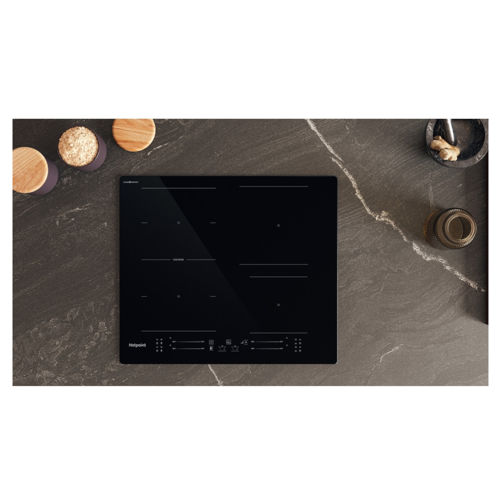 Hotpoint TS3560FCPNE induction hob featuring a sleek black glass surface, four cooking zones, and a modern design, set against a dark stone countertop with wooden bowls.