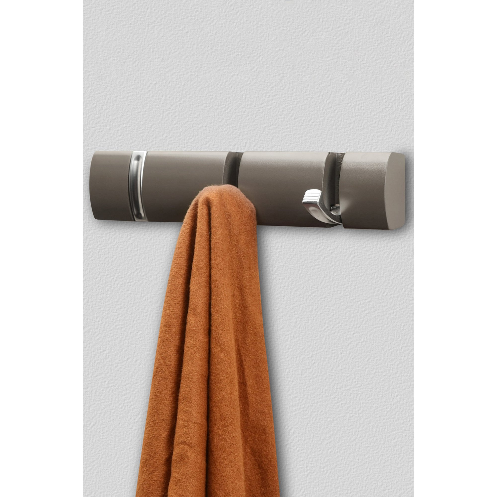 Dark grey wall-mounted coat hook with three concealed hooks, featuring a sleek design and a soft, textured surface, holding a brown-orange towel.