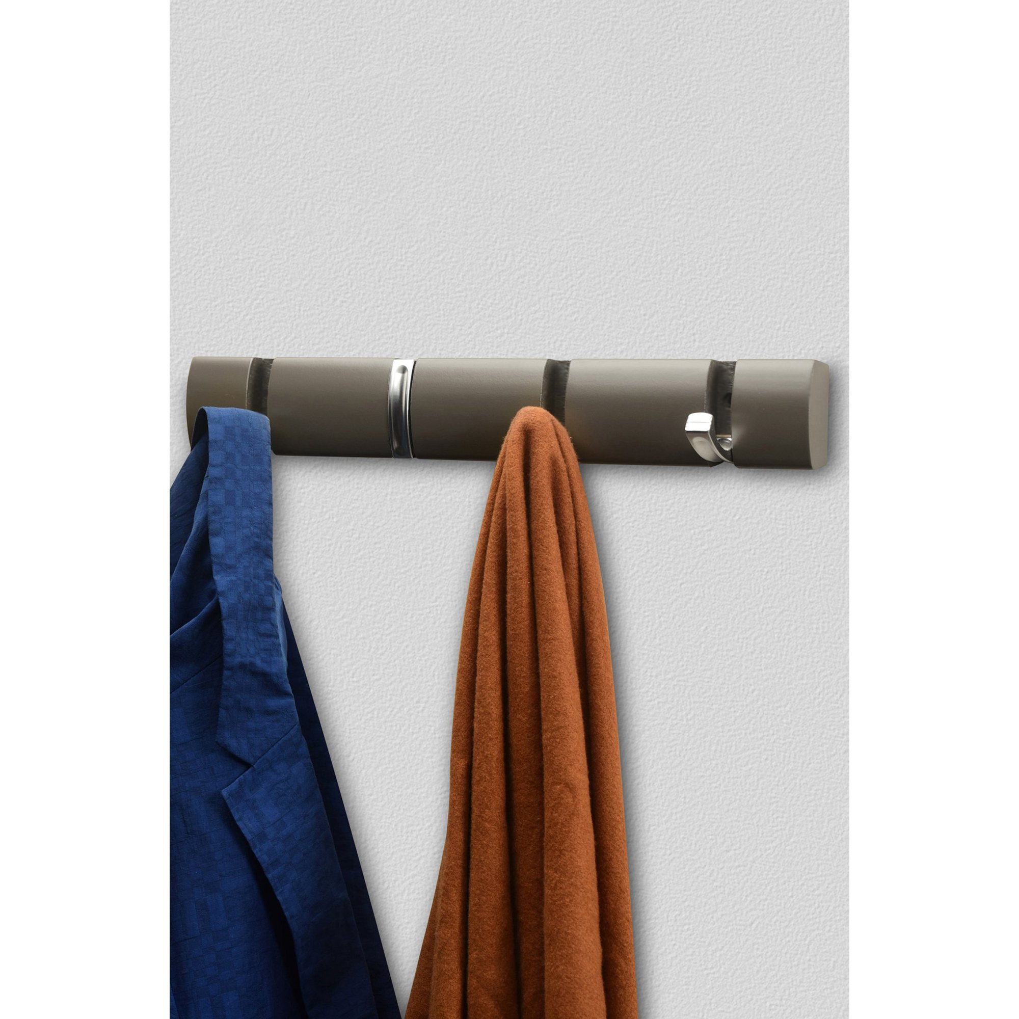 Dark grey wall-mounted coat hooks featuring four concealed hooks, with a textured finish, holding a blue jacket and an orange scarf against a light background.