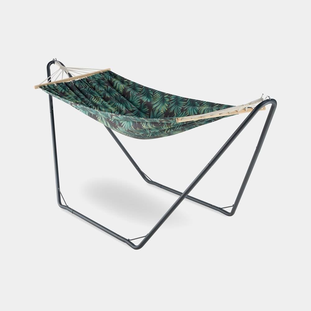 Ibiza 1-person hammock features a vibrant palm leaf pattern on durable fabric, supported by a sturdy black metal stand with a sleek, modern design.