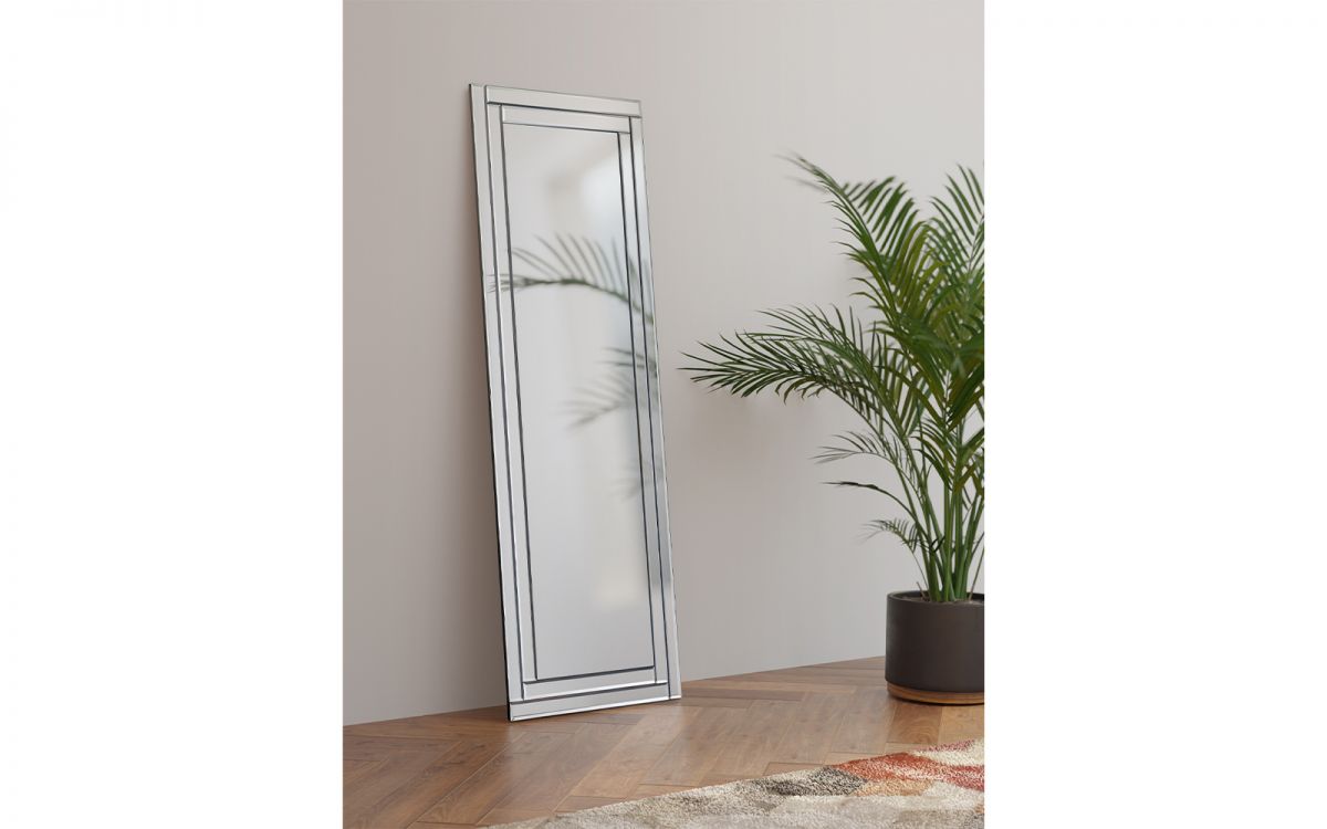 Frameless rectangular dress mirror with a sleek design, featuring a polished edge, leaning against a wall beside a potted plant on a wooden floor.