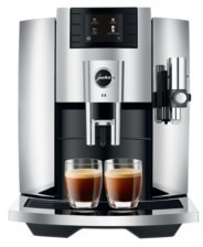 Sleek chrome Jura E8 coffee machine with a digital display, dual coffee spouts, and two cups of espresso, showcasing a modern design and high-quality finish.