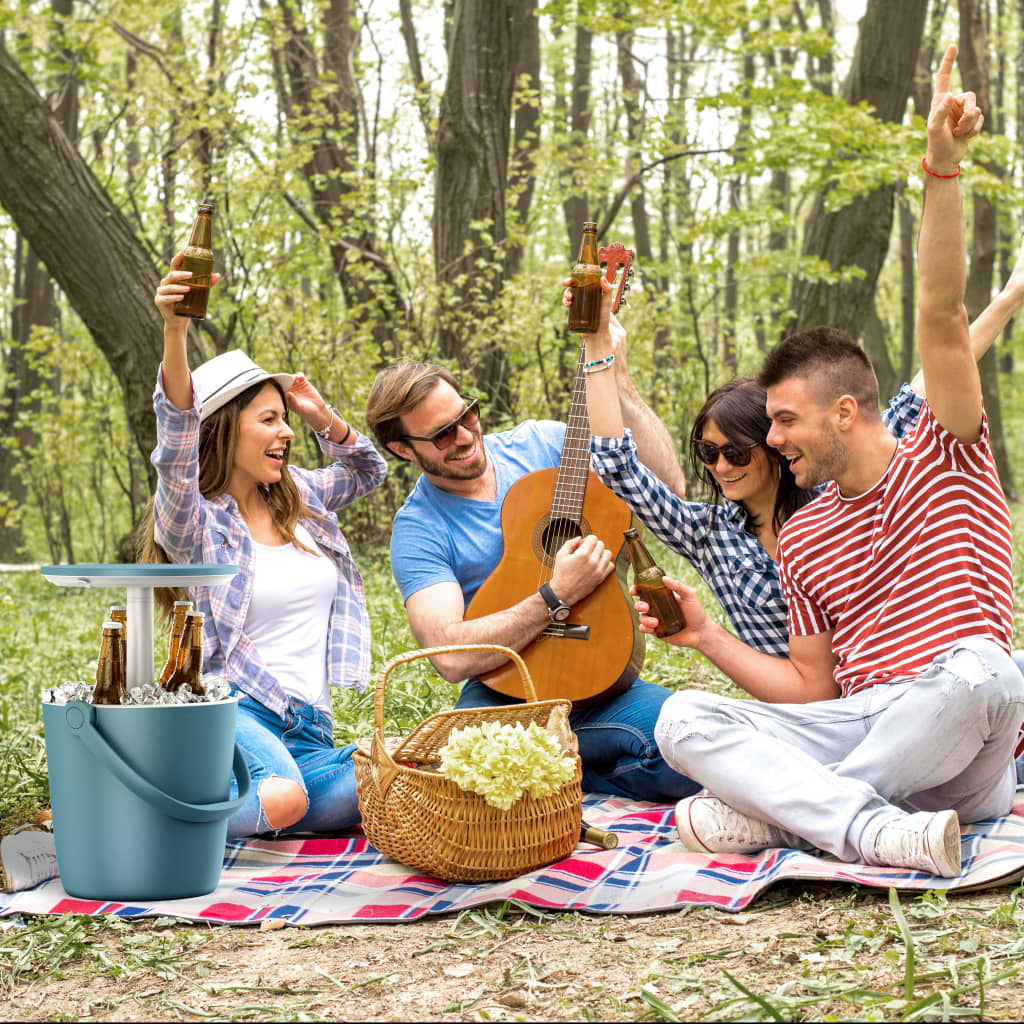 Blue 17L Go Bar cooler by Keter, featuring a sturdy design, filled with ice and drinks, surrounded by a group of friends enjoying a picnic in a forested area.