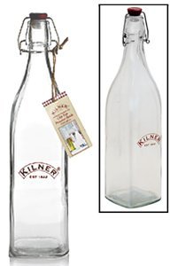 Clear glass 1-litre preserve bottle with a vintage design, featuring a metal clip top and a red rubber seal, embossed "Kilner" logo, and a rectangular base for stability.