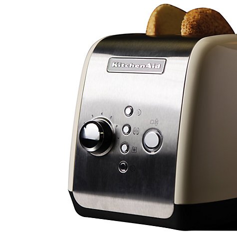Almond cream-colored KitchenAid Artisan 2 Slice Toaster with a stainless steel front, featuring a dial, buttons, and two slices of toasted bread on top.