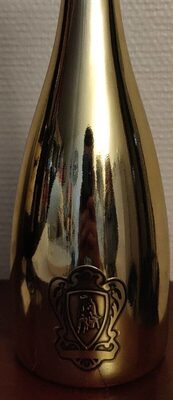 Gold-colored bottle of Lamborghini Extra Dry Gold Prosecco D.O.C. with an embossed logo, accompanied by two elegant crystal glasses, all presented in a gift set.