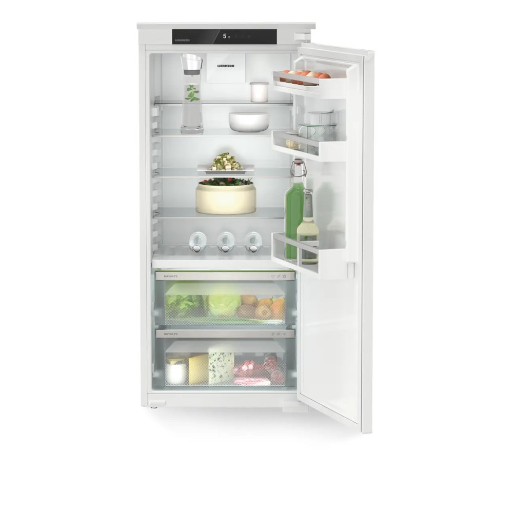 Fully integrated white Liebherr larder fridge with a sleek design, featuring multiple shelves, transparent drawers, and adjustable compartments, showcasing fresh produce and beverages inside.