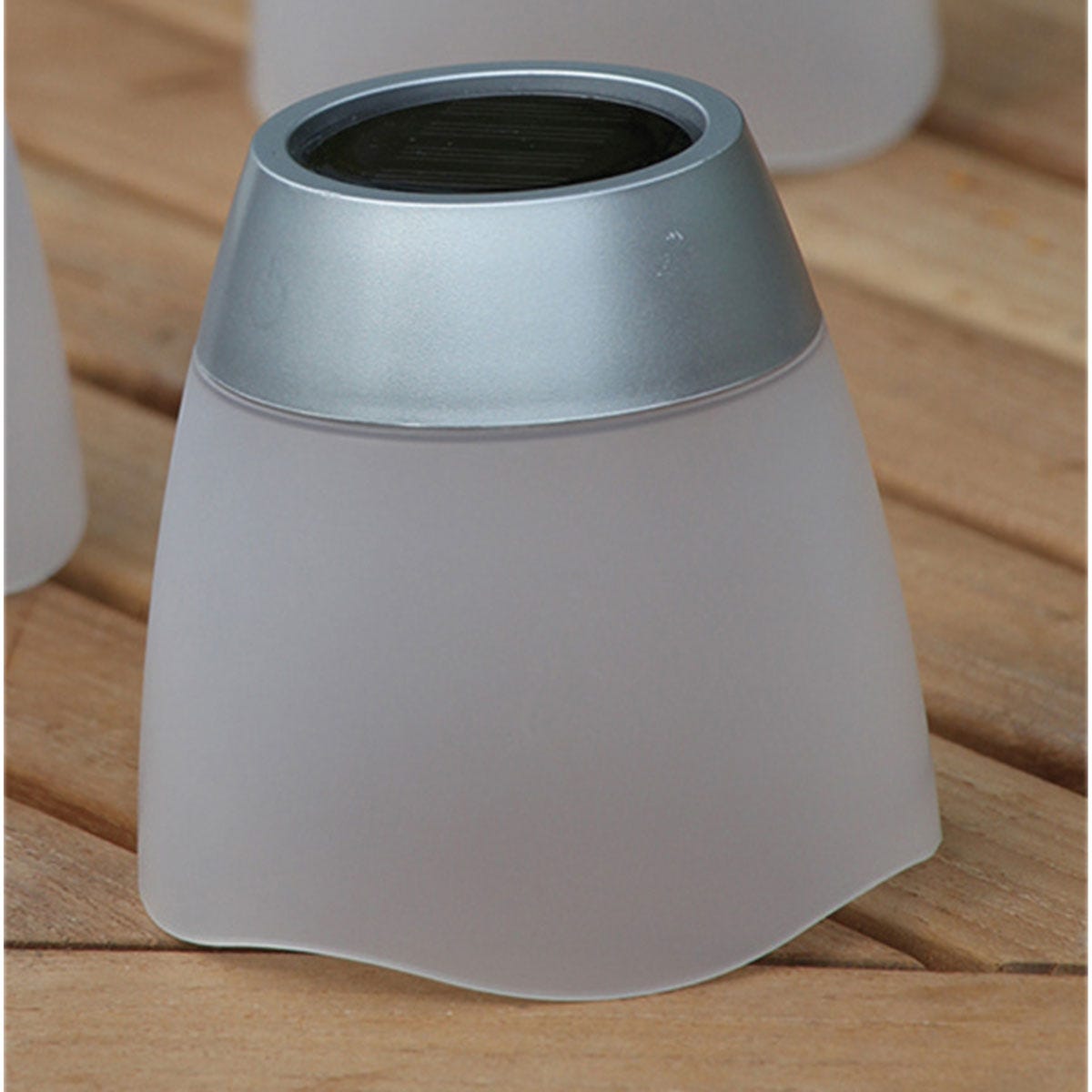 Frosted glass solar tumbler with a silver top, featuring a sleek, curved design, ideal for outdoor lighting and ambiance.