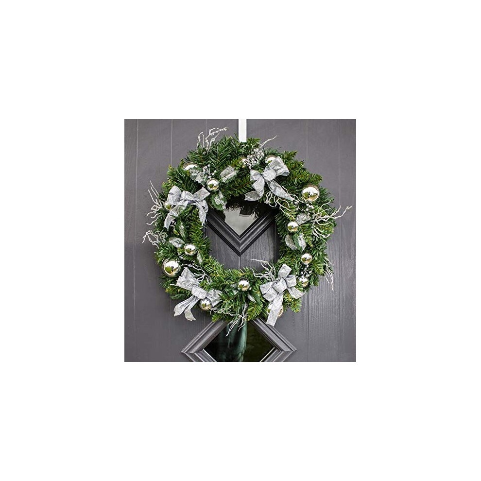 Large 50cm traditional Christmas wreath in green, adorned with silver ornaments and ribbons, featuring a mix of pine and faux foliage, hanging on a dark door.