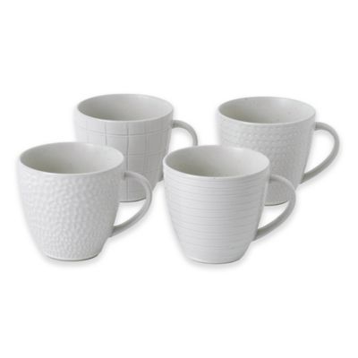 Set of four white ceramic mugs featuring mixed textures: one with a dotted pattern, another with a grid, and two with subtle ribbed designs.