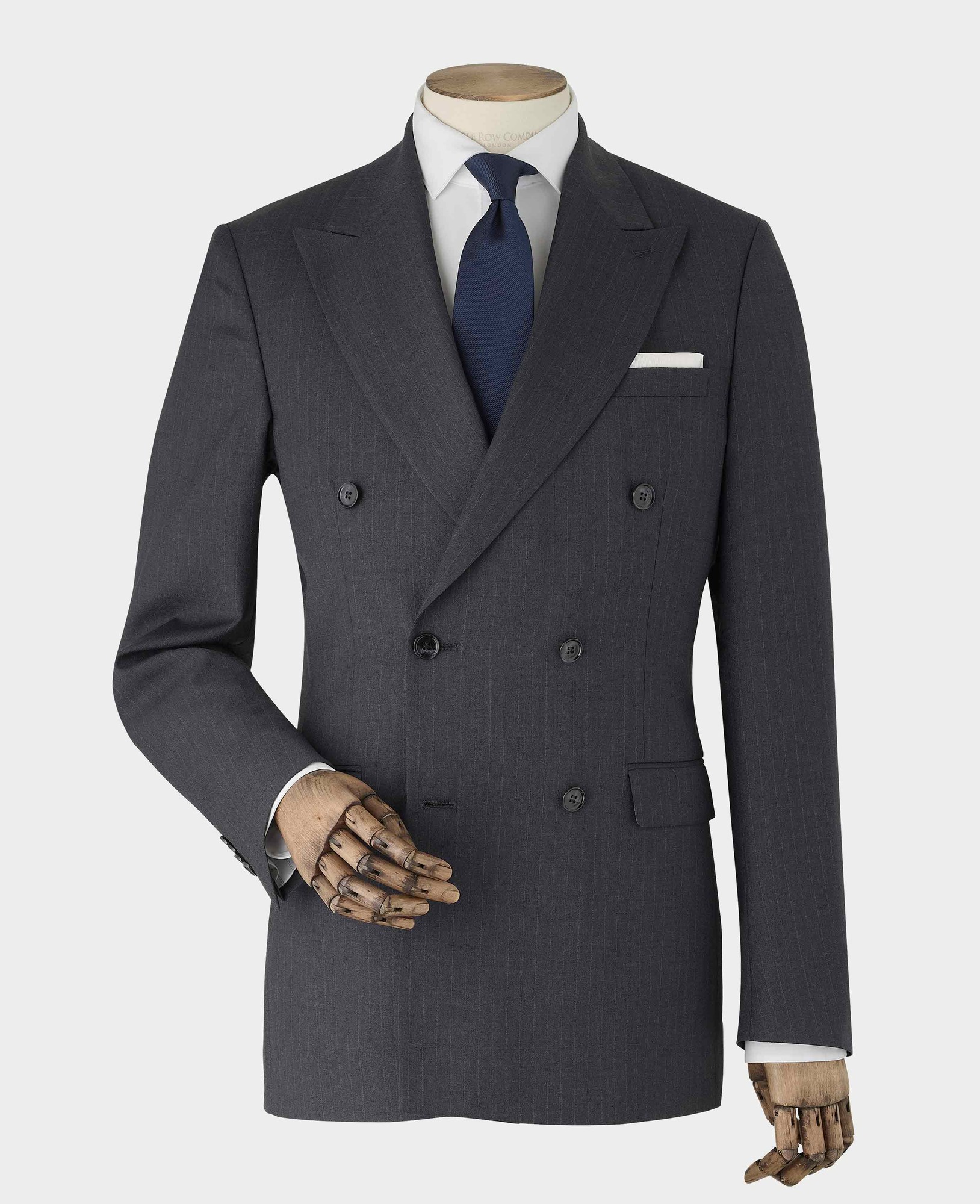 Men's grey wool blend double-breasted suit jacket featuring chalk stripes, size 40R, with a white pocket square and a navy tie, displayed on a mannequin with a wooden hand.