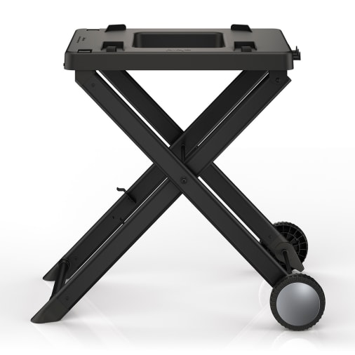 Black folding stand for the Ninja Woodfire Electric BBQ, featuring a sturdy design with a rectangular top, cross-braced legs, and two wheels for easy mobility.