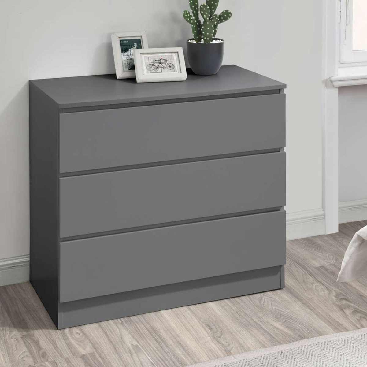 Birlea Oslo 3 Drawer Chest in grey, featuring a sleek, modern design with three spacious drawers and a minimalist aesthetic, placed on a wooden floor near a window.