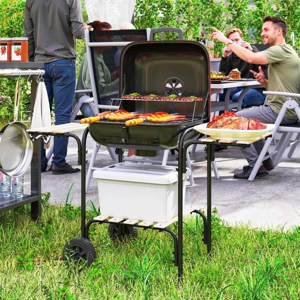 Portable red charcoal barbecue grill with a lockable lid, vent, and side shelves, featuring a sturdy black frame and wheels for easy mobility, set in a backyard scene.