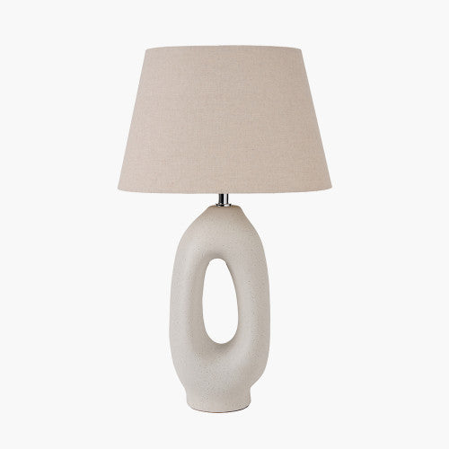 Ceramic table lamp with a neutral cream finish, featuring an abstract oval base and a soft beige linen shade, perfect for a boho aesthetic.