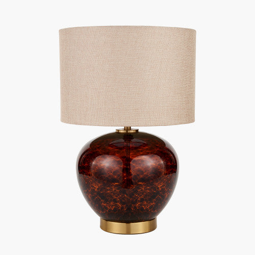 Tall table lamp featuring a tortoiseshell glass base in rich amber tones, complemented by a beige fabric shade and a gold-tone base.
