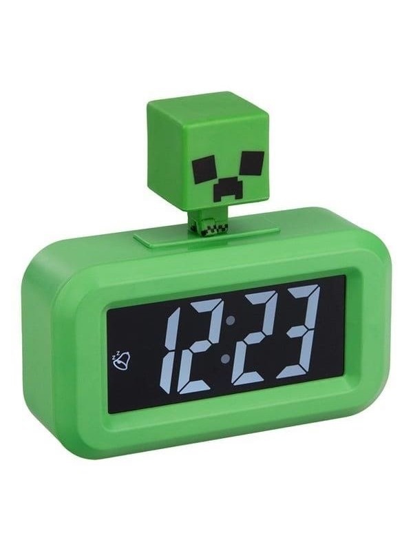 Green alarm clock shaped like a Minecraft Creeper, featuring a blocky head on top and a digital display showing the time in white numerals against a black background.
