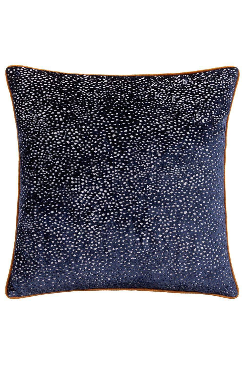 Navy cut velvet cushion featuring a spotted design and piped edges in a contrasting color, adding a touch of elegance to any decor.