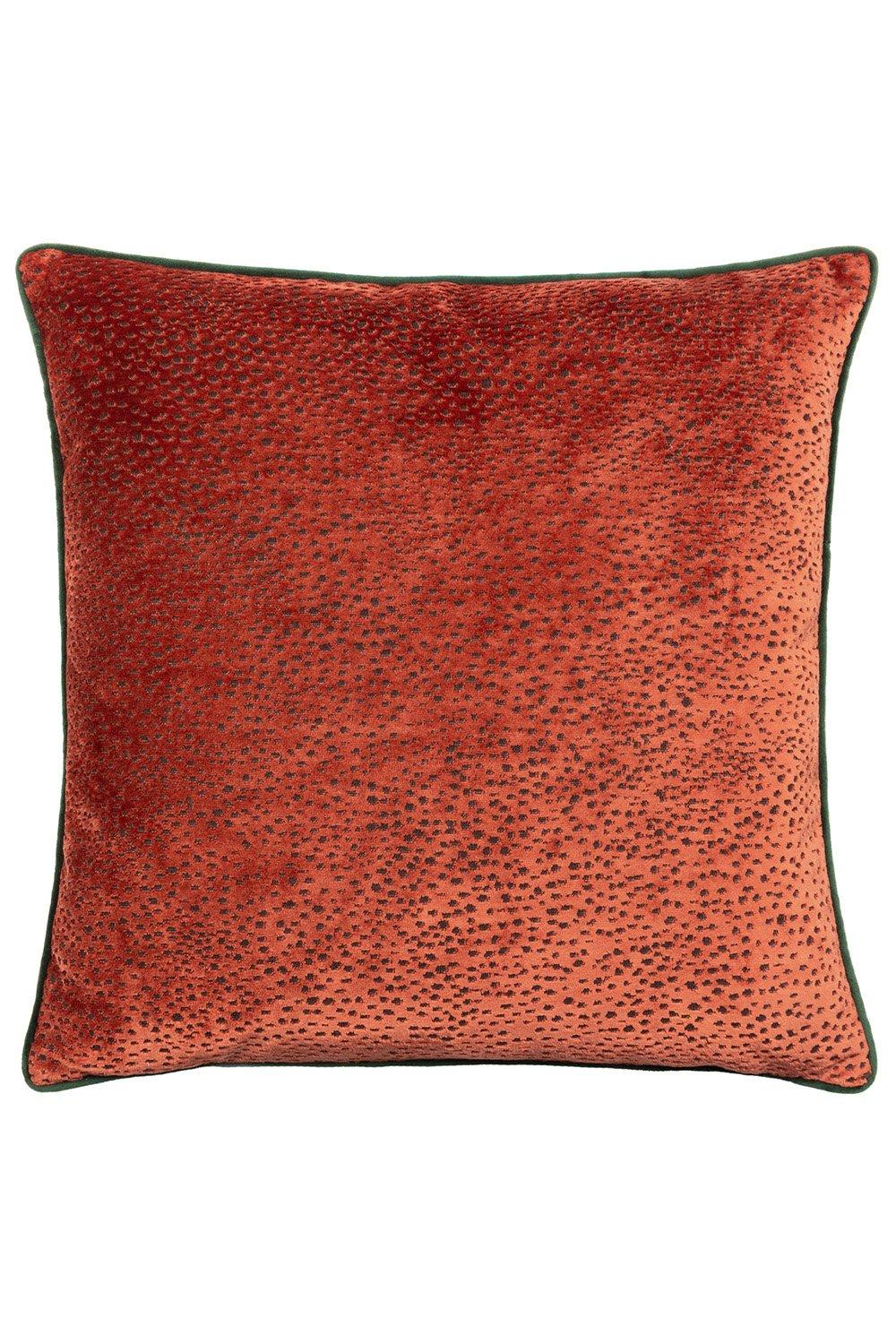 Orange cut velvet cushion featuring a spotted design and piped edges in a contrasting dark green, adding a touch of texture and style to any decor.