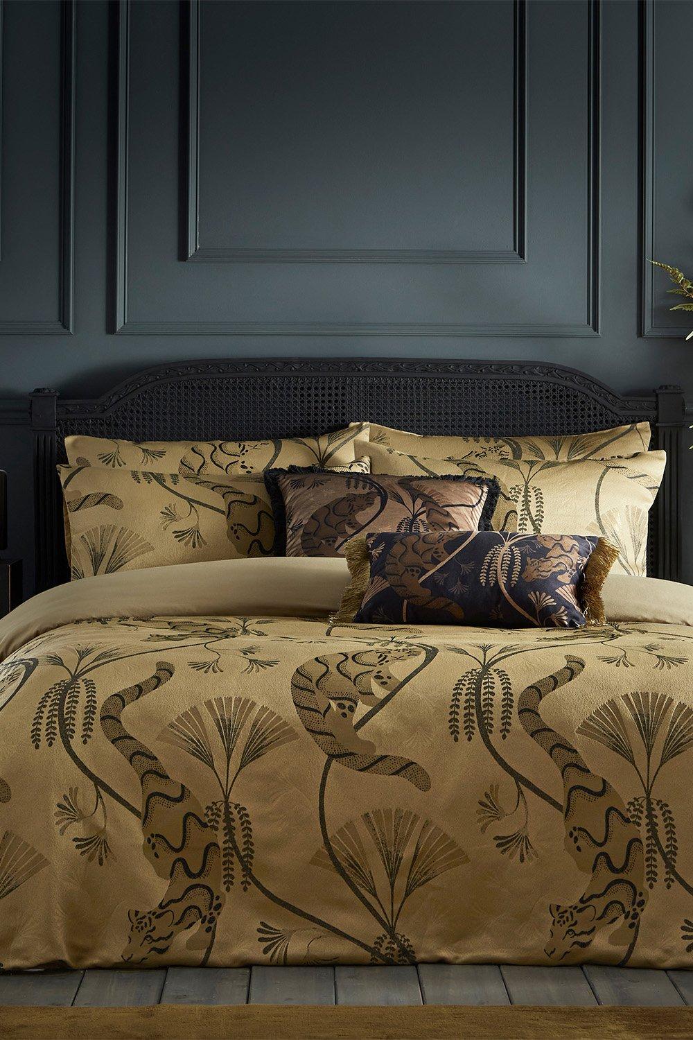 Yellow jacquard double duvet cover set featuring intricate floral patterns in dark tones, complemented by matching decorative pillows, set against a dark paneled wall.