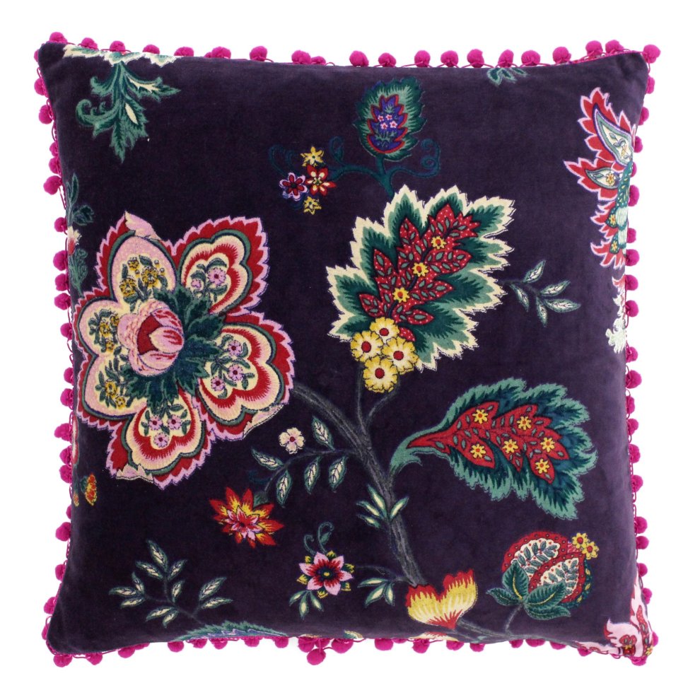 Purple floral printed cushion featuring vibrant multicolored flowers and leaves, trimmed with bright pink pom poms, measuring 50cm x 50cm.
