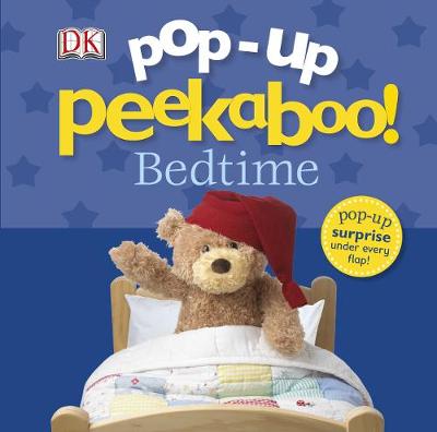 A colorful children's book titled "Pop-up Peekaboo! Bedtime" featuring a plush teddy bear in a red nightcap, nestled in a wooden bed with a patchwork quilt, set against a starry blue background.