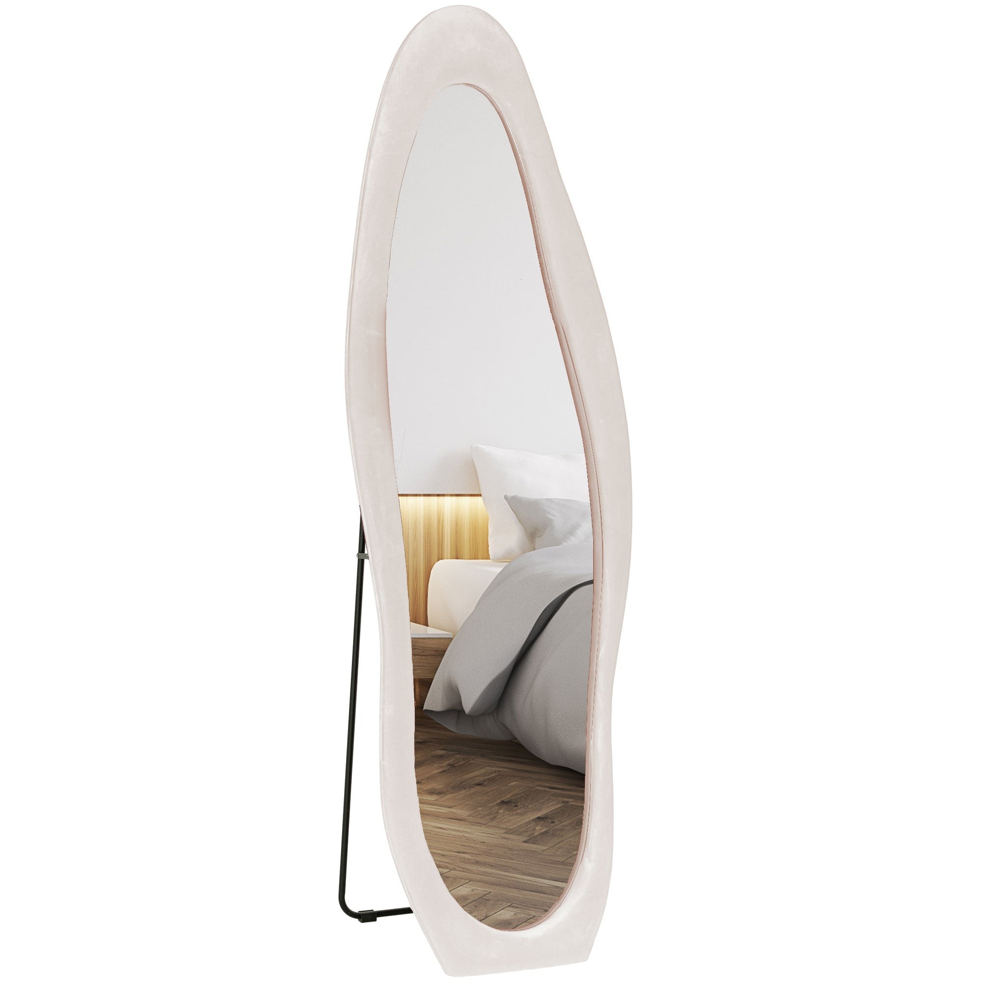 Irregular full-length mirror with a light pink velvet frame, measuring 160 x 50 cm, standing on a black metal support, reflecting a modern bedroom setting.