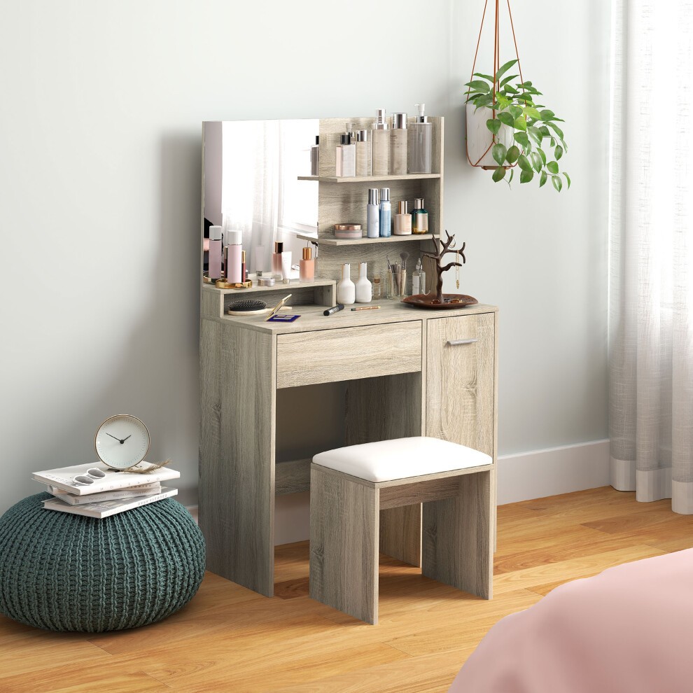 Modern vanity table in natural wood finish with a large mirror, storage shelves, and a cushioned stool, set against a light wall and wooden floor.