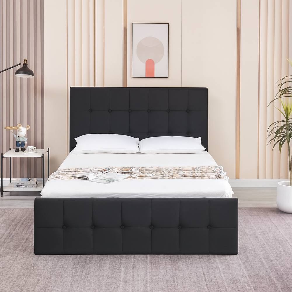Black velvet ottoman bed with gas lift storage, featuring a cushioned headboard and a small double size, set against a modern bedroom backdrop with light-colored walls.