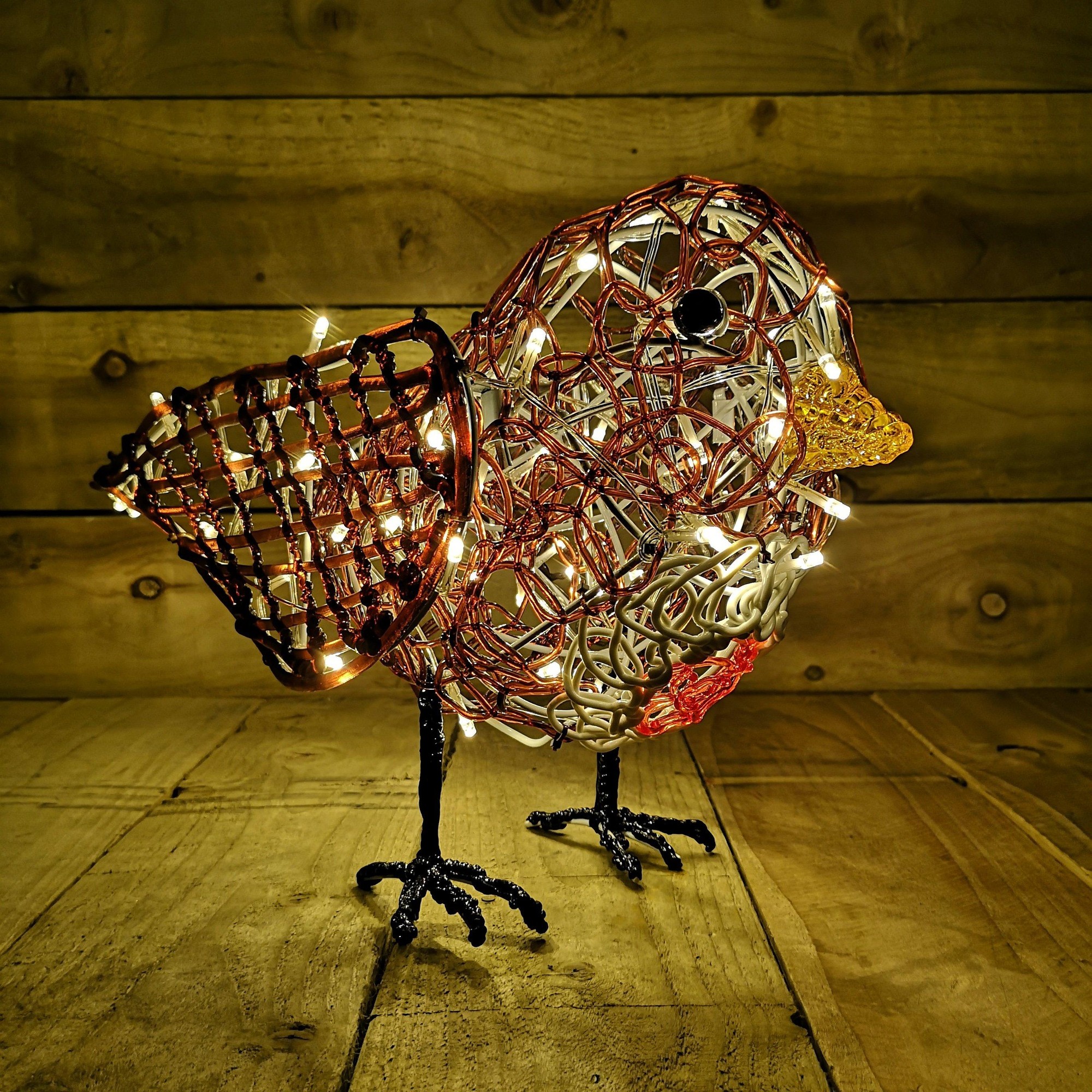 30cm soft acrylic outdoor Christmas robin with a warm white LED glow, featuring a woven body in red and brown, a yellow beak, and black feet, set against a wooden background.
