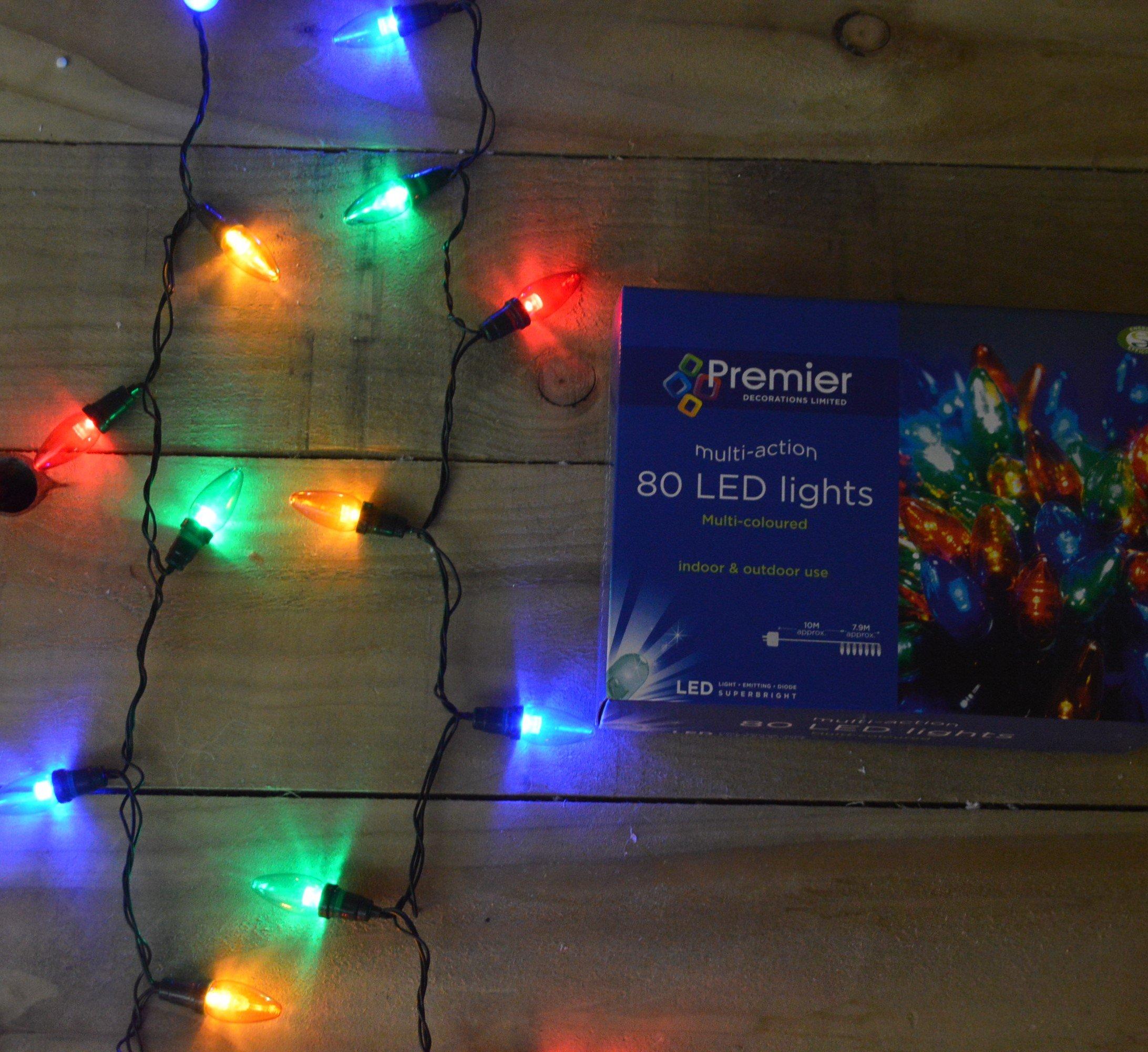 Multi-coloured Premier 80 LED Christmas lights (7.9m) with a black wire, featuring vibrant red, green, blue, and yellow bulbs, alongside the product box on a wooden surface.