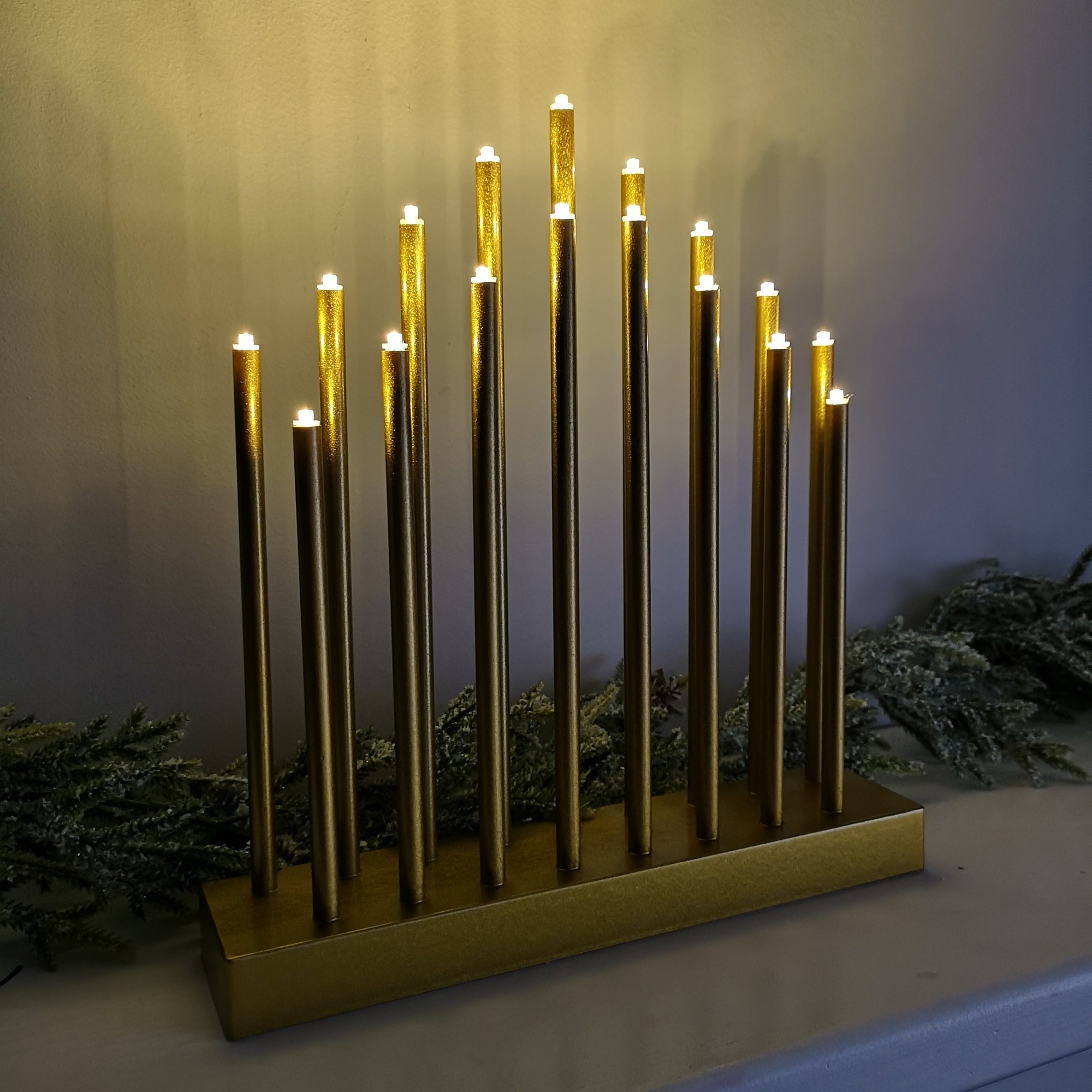 Gold 29cm candle bridge with 17 LED lights, featuring tall, slender candle-like structures and a sturdy base, designed for battery operation with a timer function.