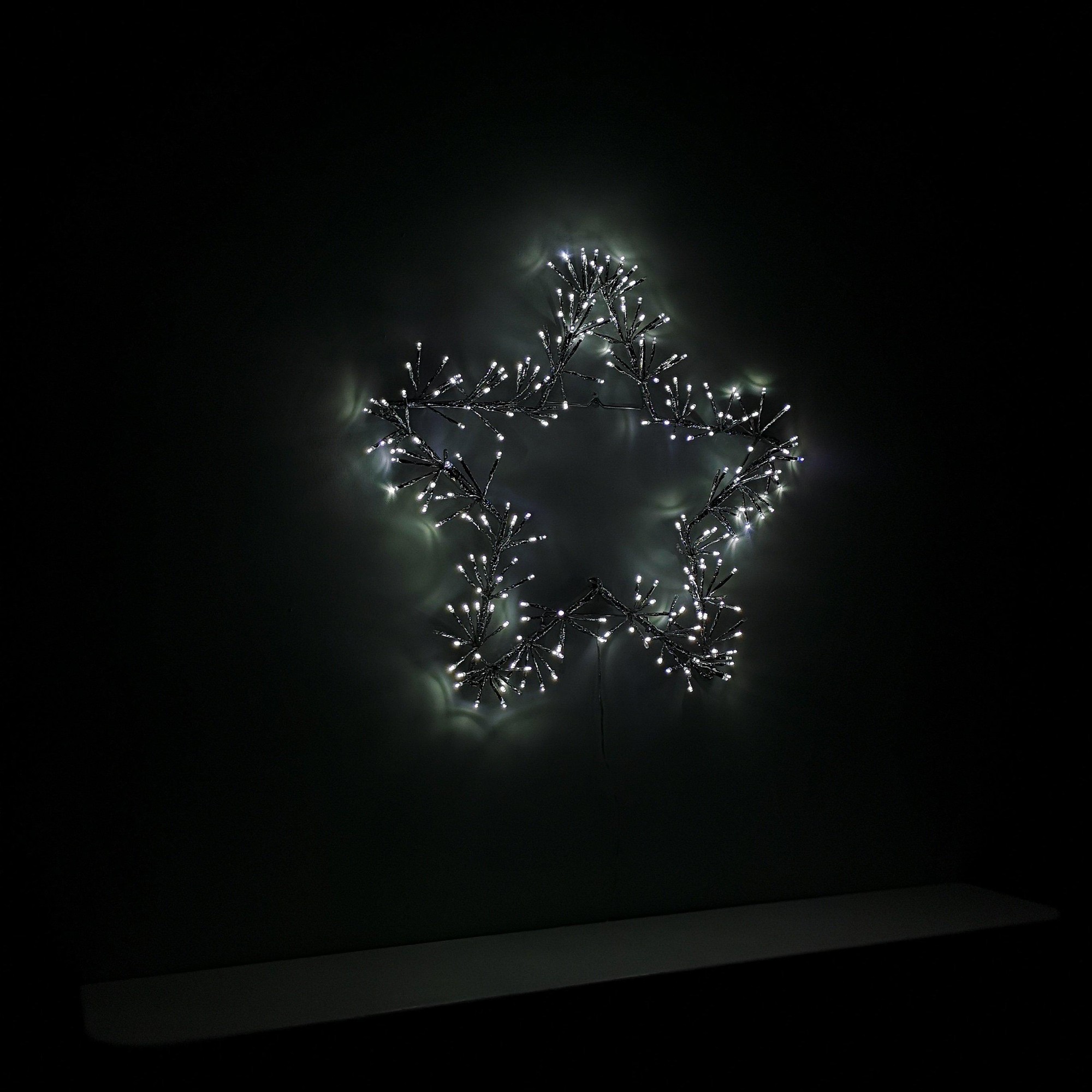 60cm silver star silhouette decoration with twinkling cool white LED lights, featuring a delicate branch-like design, set against a dark background.