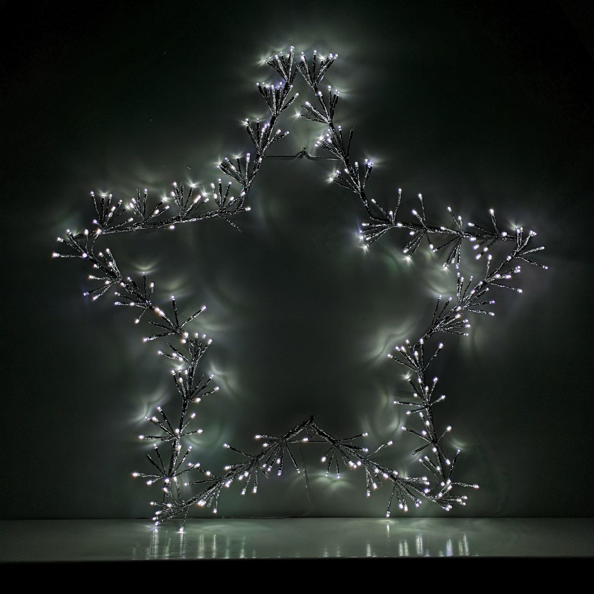 90cm silver star silhouette decoration featuring twinkling cool white LED lights, designed with a metallic finish and intricate branch-like detailing.