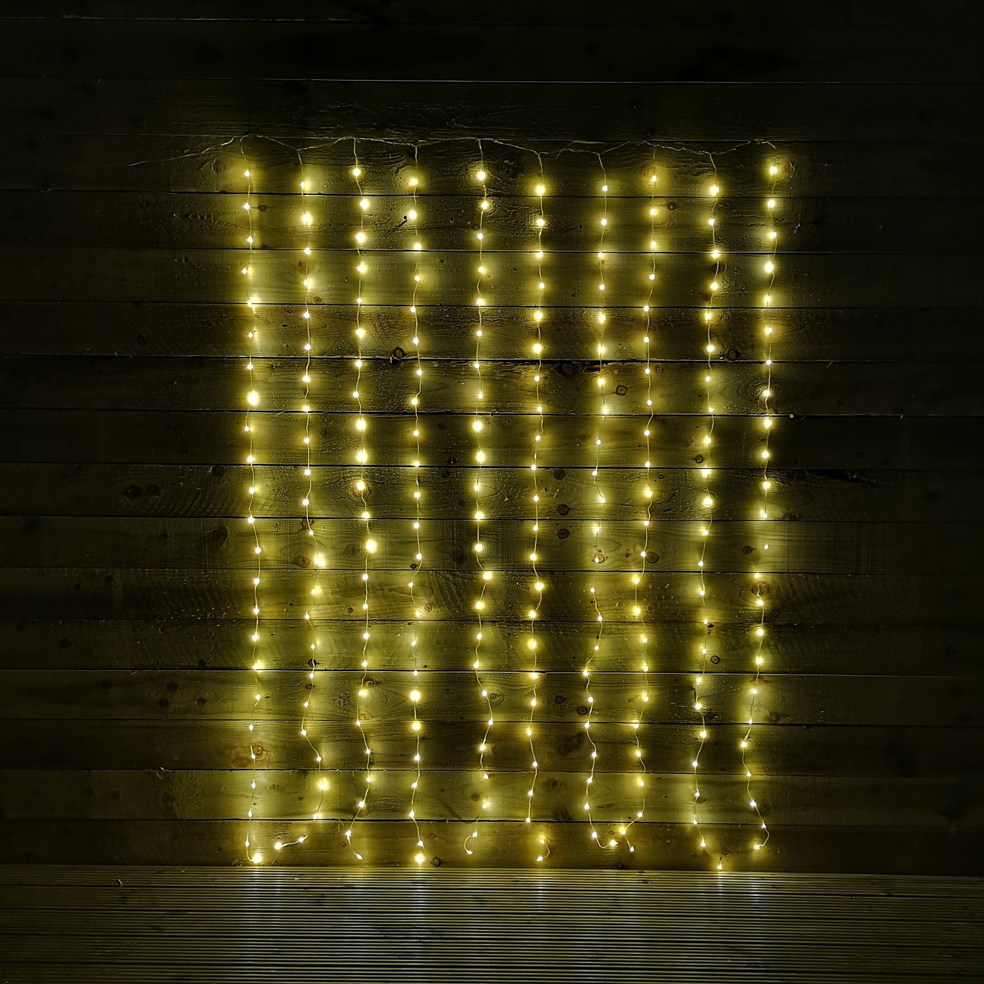 Warm white LED curtain lights with 240 bulbs, measuring 2M x 1.5M, featuring a flexible design for indoor or outdoor use, complete with a timer function.