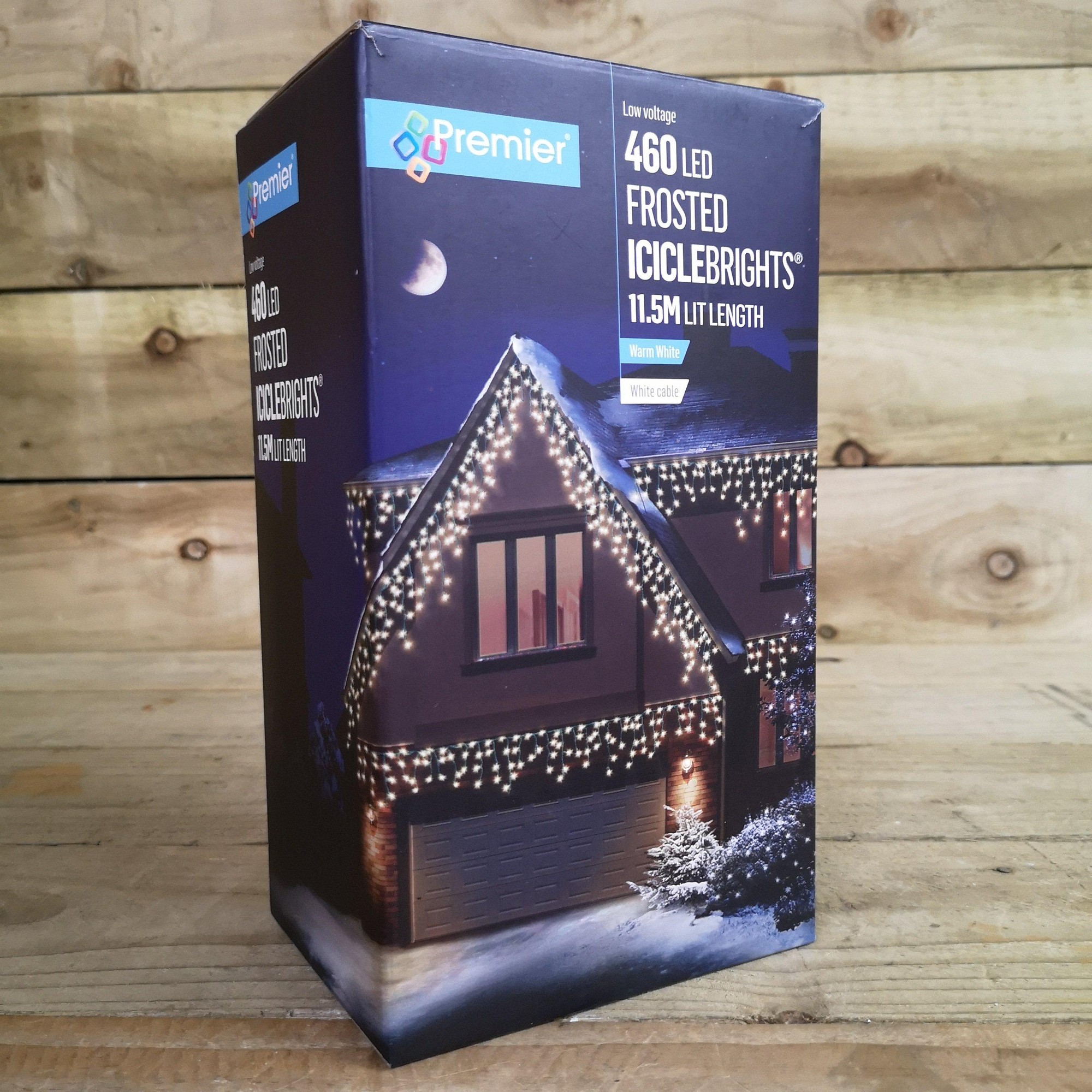 Premier's 460 LED warm white icicle lights in a 11.5m length, featuring a frosted design, displayed in a decorative box against a wooden background.
