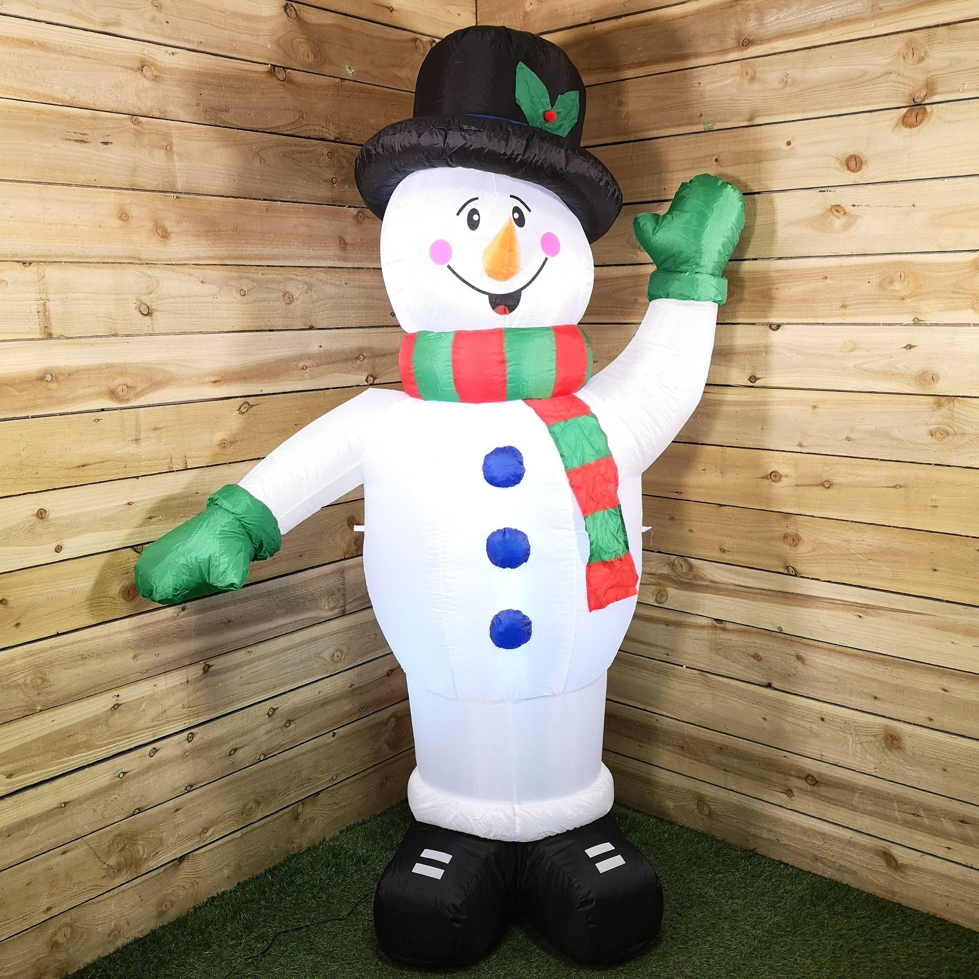 1.8m tall inflatable snowman with a black top hat, green gloves, a red and green striped scarf, and LED lights, set against a wooden backdrop.