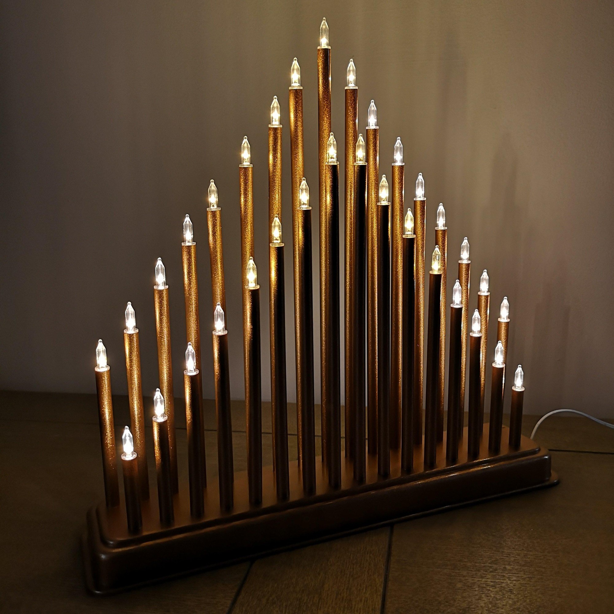 34cm rose gold Christmas candlebridge featuring 33 warm white LEDs, with tall, slender candle-like structures on a rectangular base.