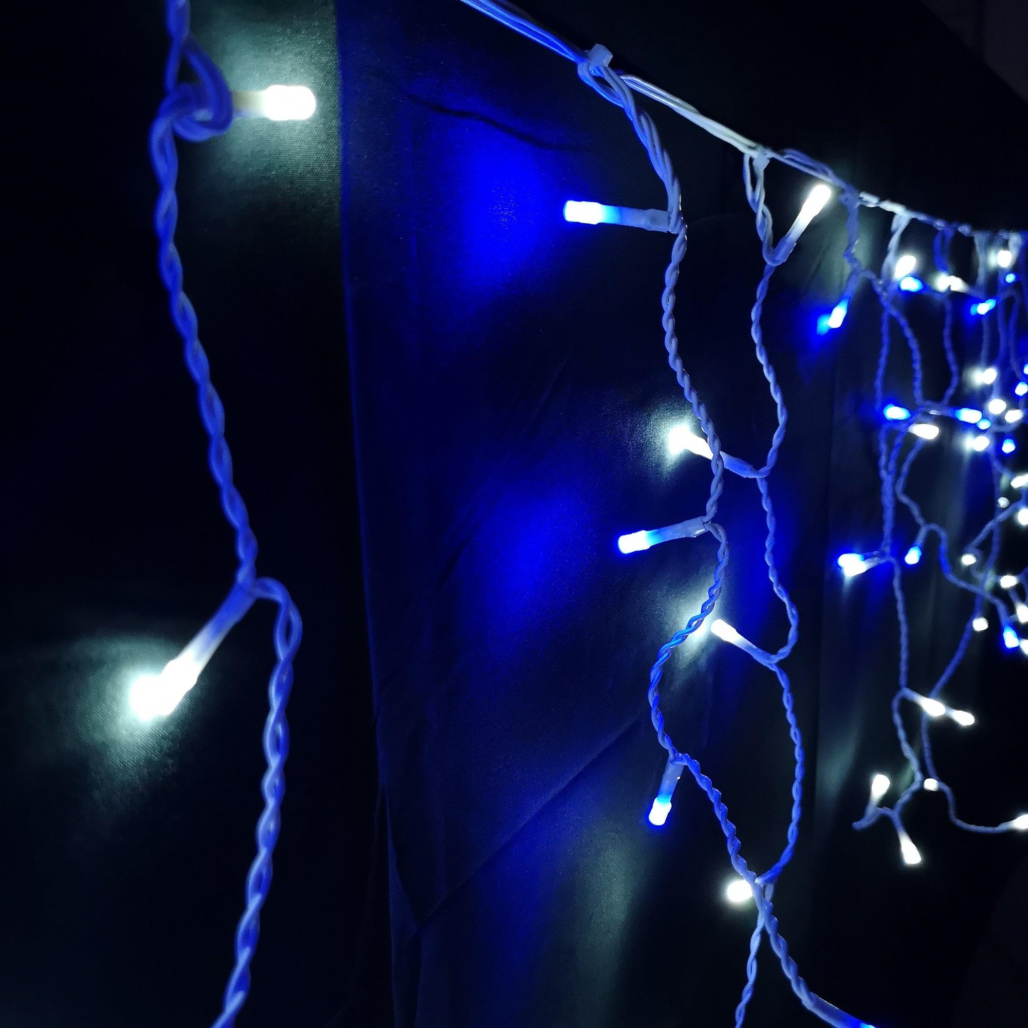 Blue and white LED icicle lights with a 16-meter length, featuring a twisted white wire and 8 different lighting functions for outdoor Christmas decoration.