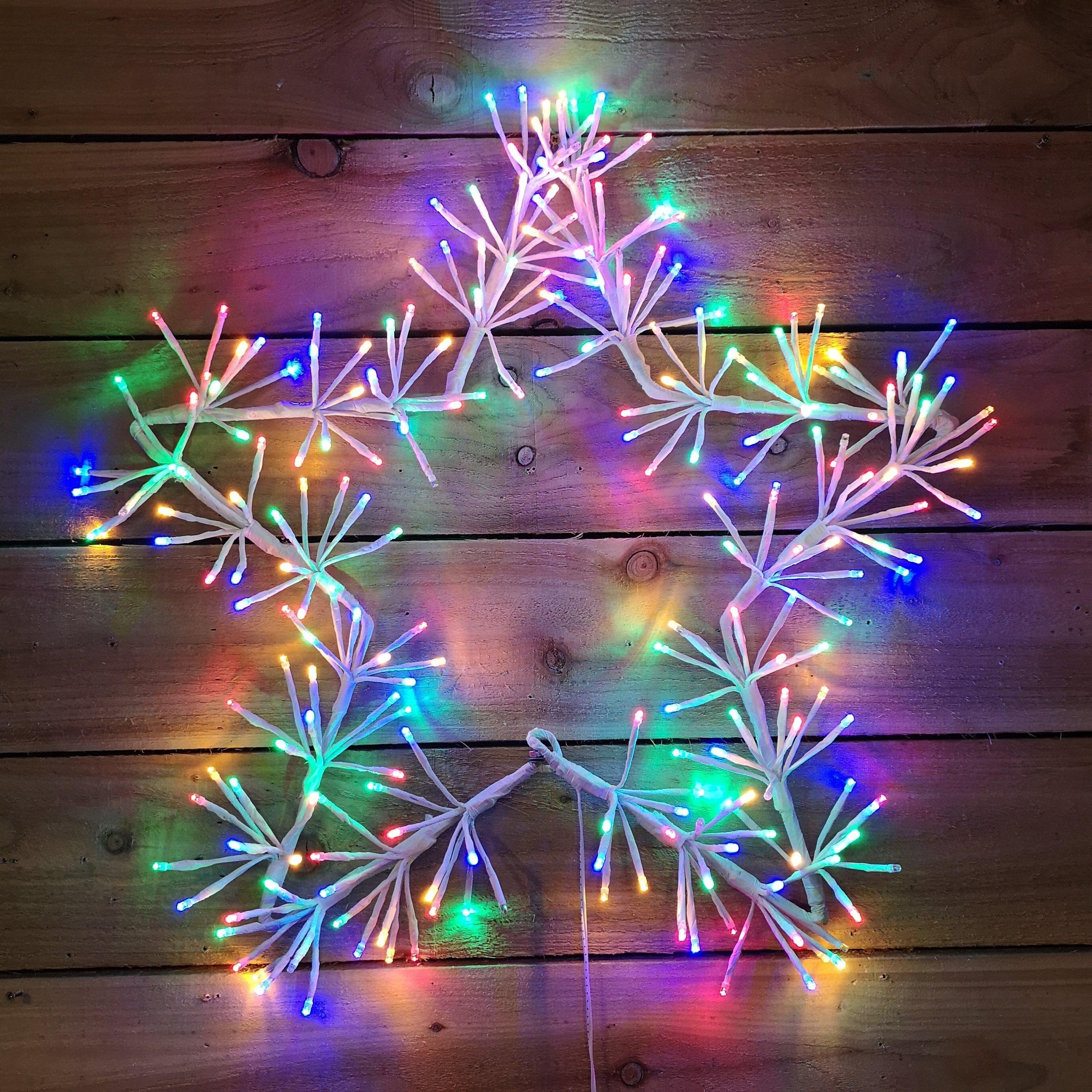 60cm multi-coloured Christmas star cluster decoration featuring 240 LED lights, with a white branch-like structure and vibrant, twinkling lights in various colours.