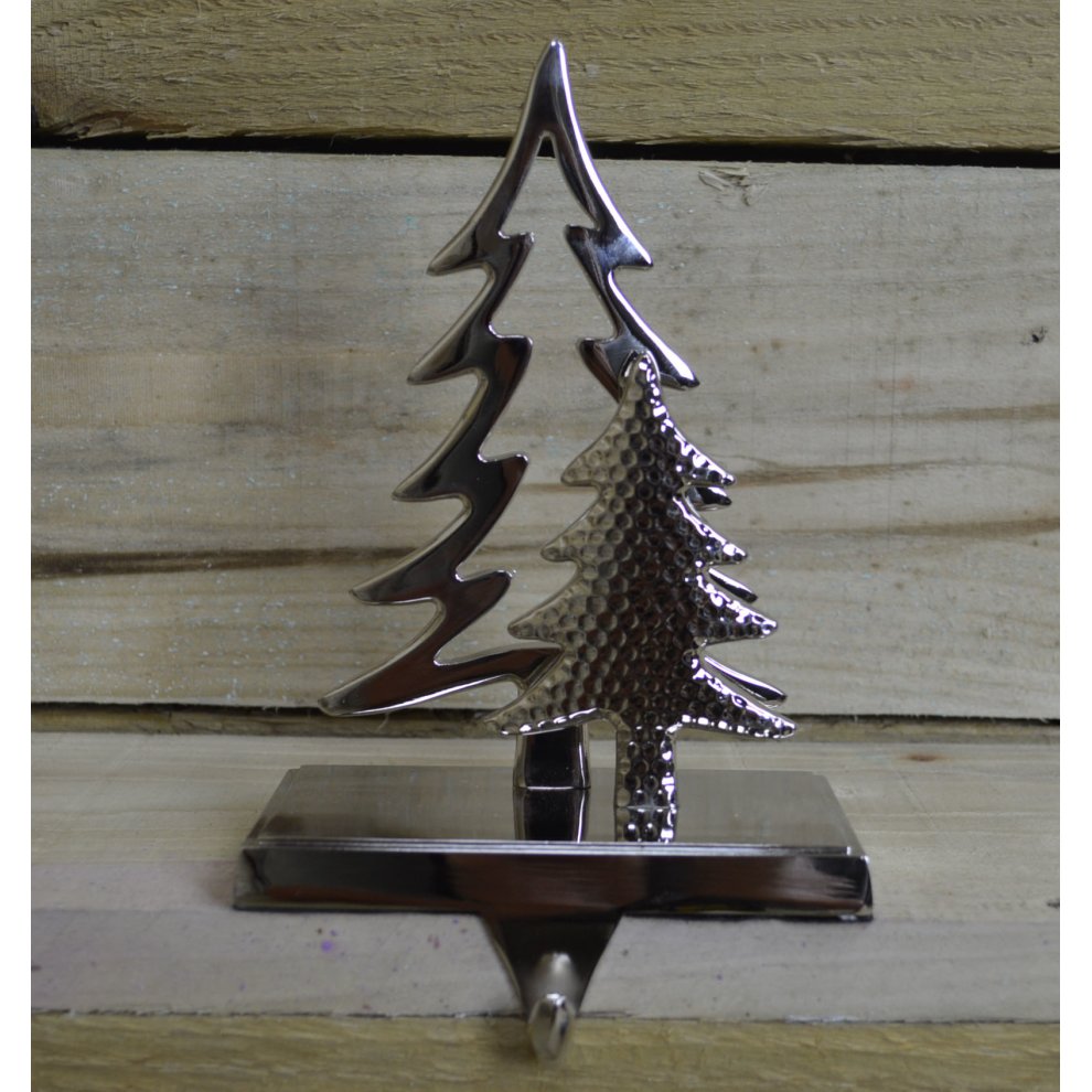 Silver decorative stocking hanger featuring two stylized trees, one smooth and one textured, mounted on a sturdy base, ideal for fireplaces or windows.