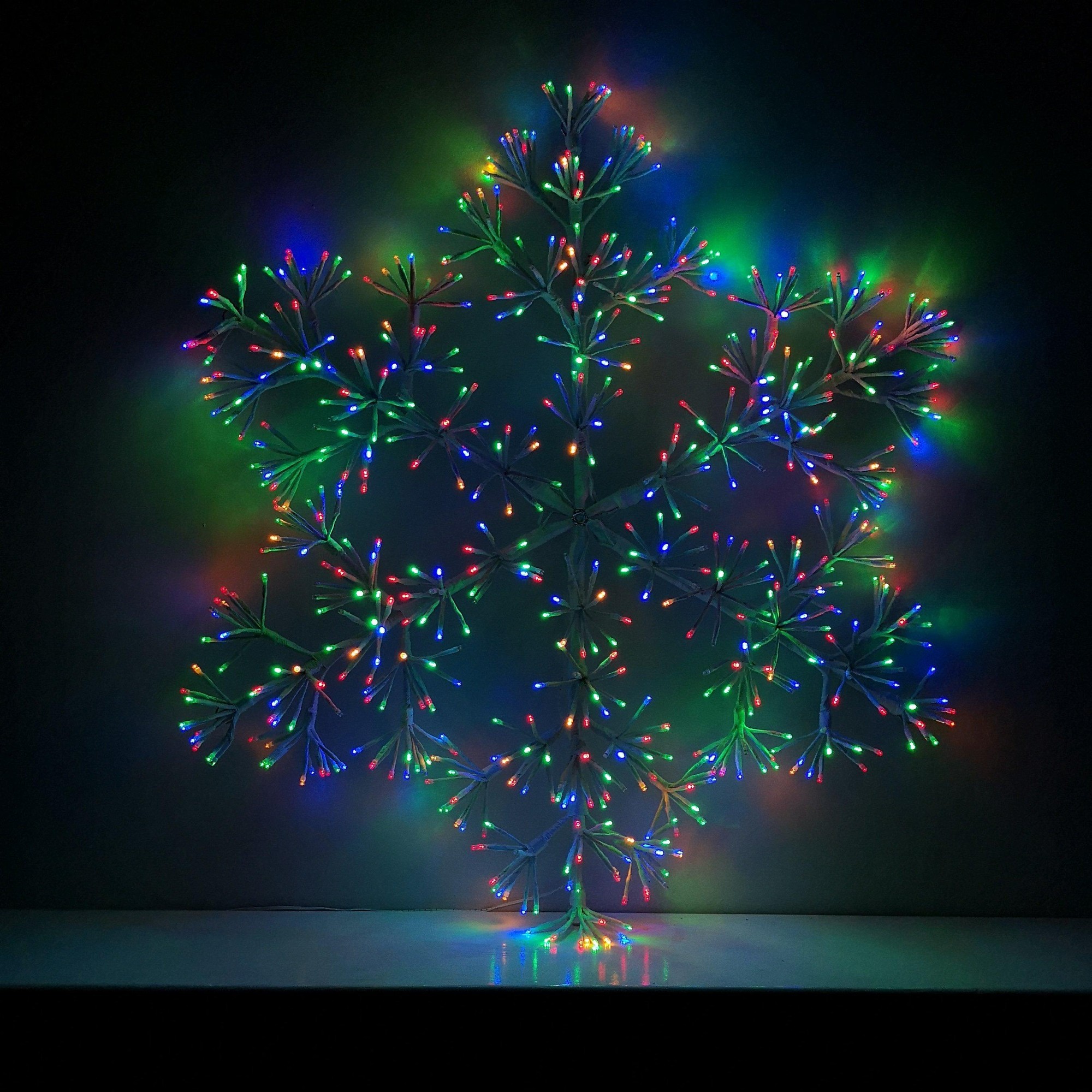 90cm white starburst snowflake decoration featuring multicoloured twinkling LEDs, with a delicate design and vibrant light display, ideal for festive decor.