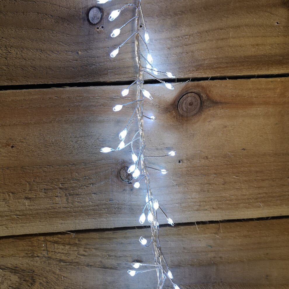 800 LED cluster lights in cool white on a flexible wire, featuring a timer function, displayed against a rustic wooden background.